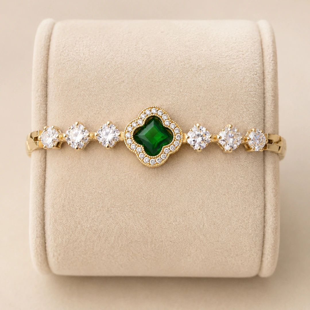 Bracelet trèfle vert à pierres claires rondes sur présentoir en velours beige, vue rapprochée