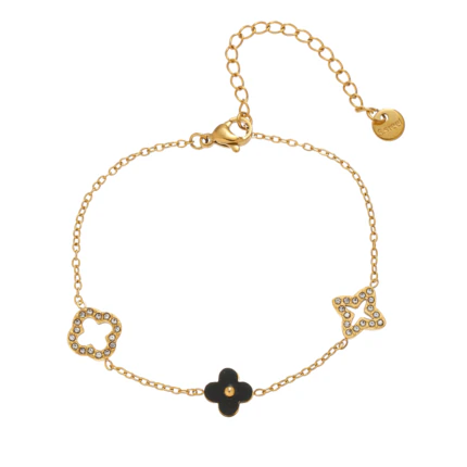 Bracelet doré à trèfle noir central, motifs ajourés sertis de strass et chaînette de rallonge sur fond blanc