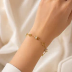 Femme portant au poignet un bracelet doré à fleurs ajourées et détails brillants