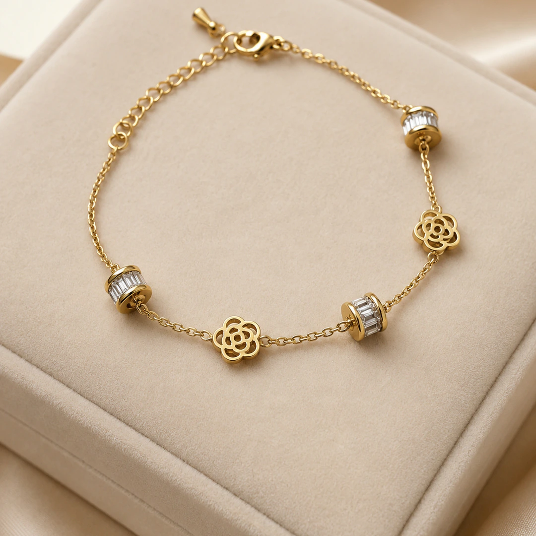 Bracelet chaîne fine doré femme à fleurs ajourées et perles serties de strass baguette, sur un écrin
