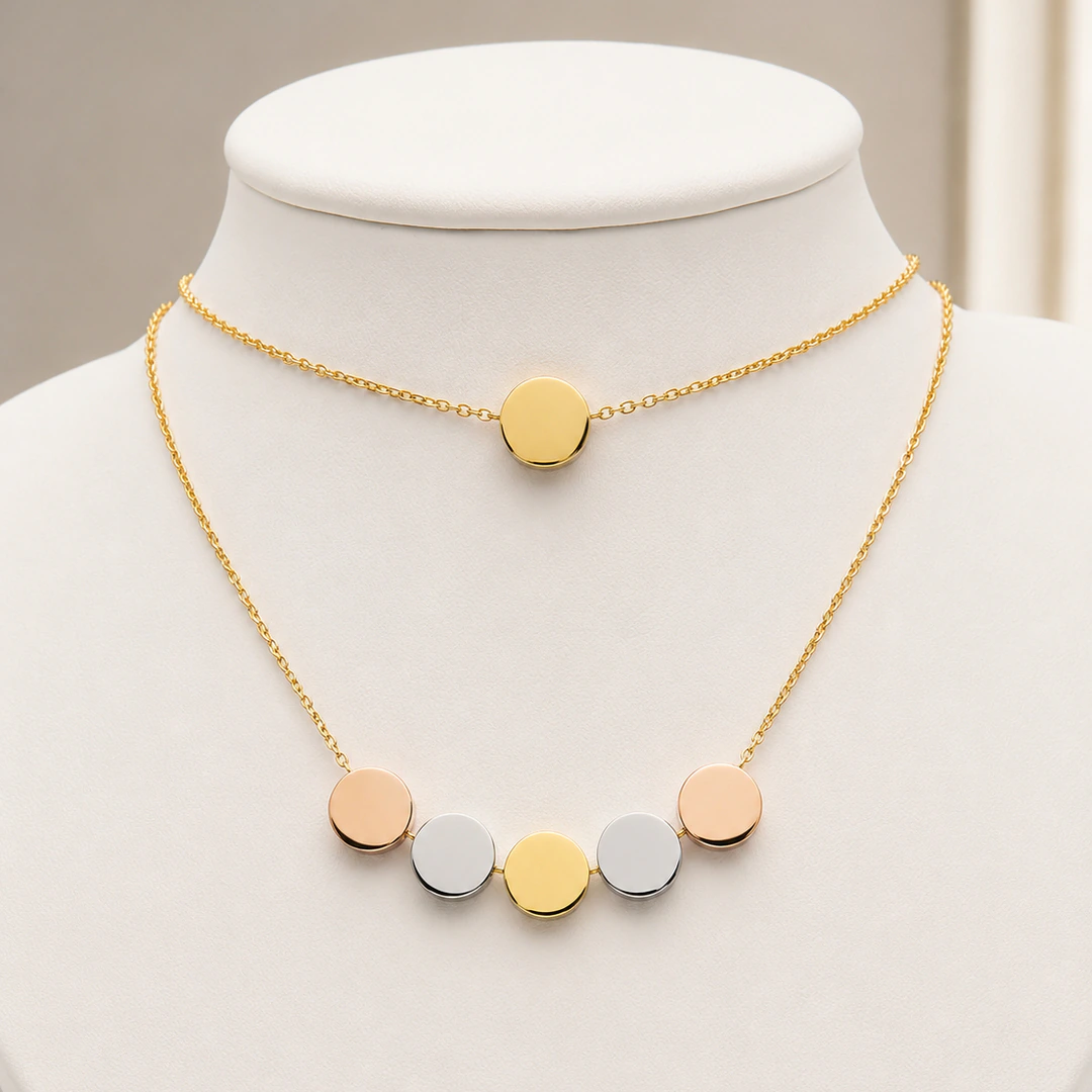 Collier deux rangs à disque doré et rangée de pastilles rose doré, argentées et dorées sur buste