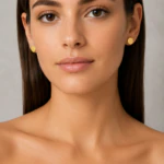 Femme portant des puces d'oreilles rondes dorées minimalistes, vue de face