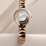 Montre femme rose doré à cadran blanc ajouré et bracelet à maillons facettés, vue de près