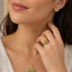 Collier pendentif éventail doré à perles turquoise porté au cou avec bague et boucle assorties