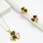 Pendentif trèfle doré à trois cœurs rouge, vert et rose bordés de strass et puces d'oreilles assorties