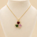 Collier femme chaîne fine dorée à pendentif trèfle multicolore sur buste de présentation