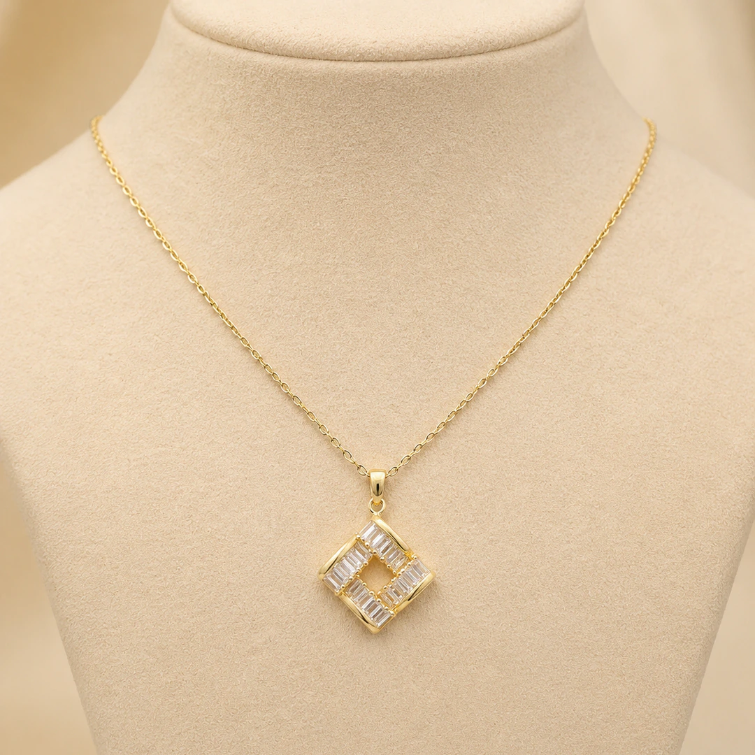 Collier chaîne fine doré à pendentif carré ajouré serti de cristaux sur buste beige