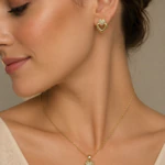 Parure dorée femme portée : collier pendentif double cœur à strass et boucles d'oreilles cœur assorties