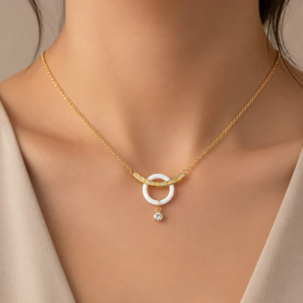 Collier chaîne fine doré à anneau blanc et petit cristal suspendu porté au cou