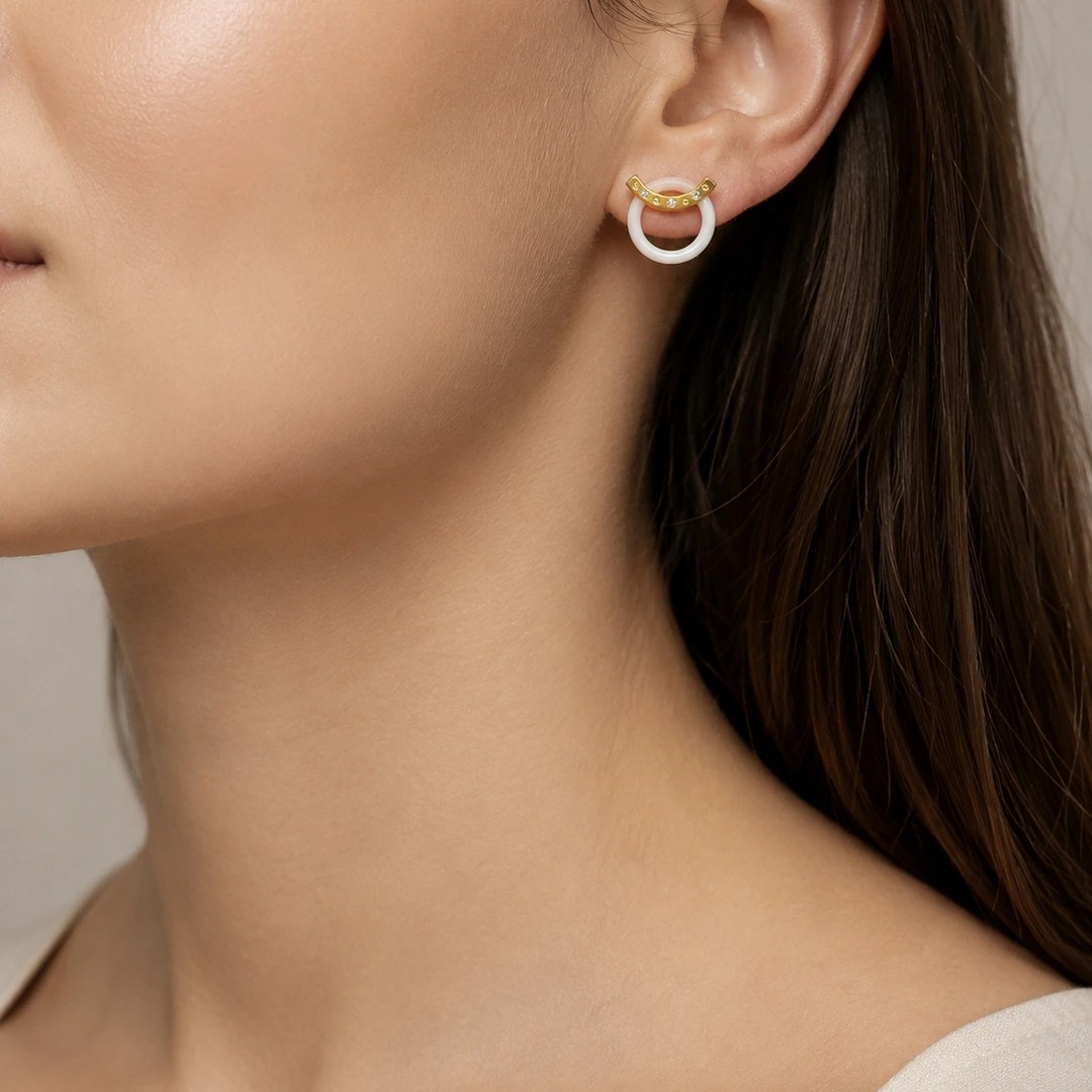 Boucle d'oreille anneau blanc et barre dorée à strass portée à l'oreille