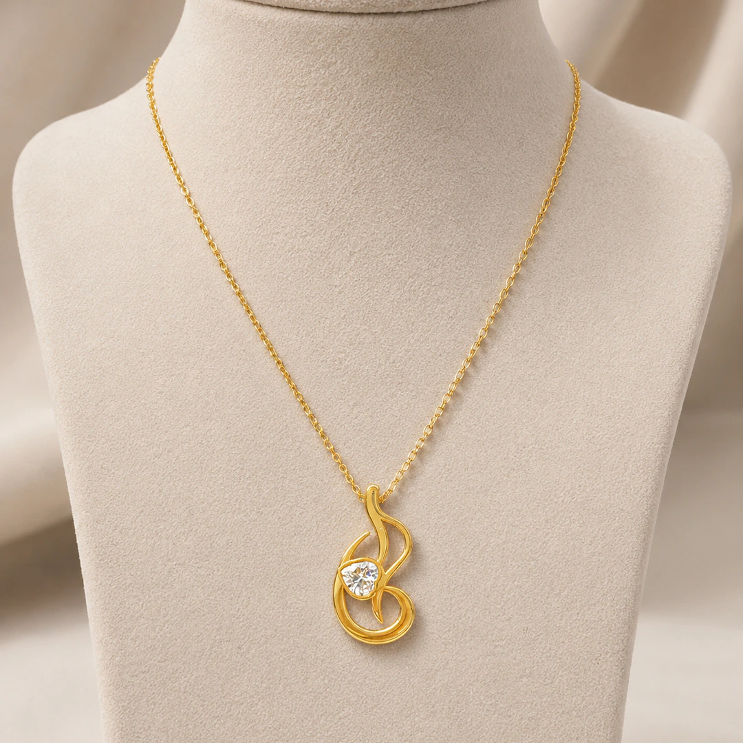 Pendentif arabesque doré aux courbes ajourées et cristal rond sur buste de présentation
