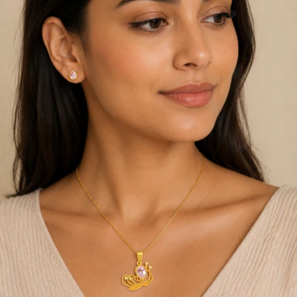 Parure dorée femme portée : collier pendentif escargot à pierre rose et puces d'oreilles goutte rose