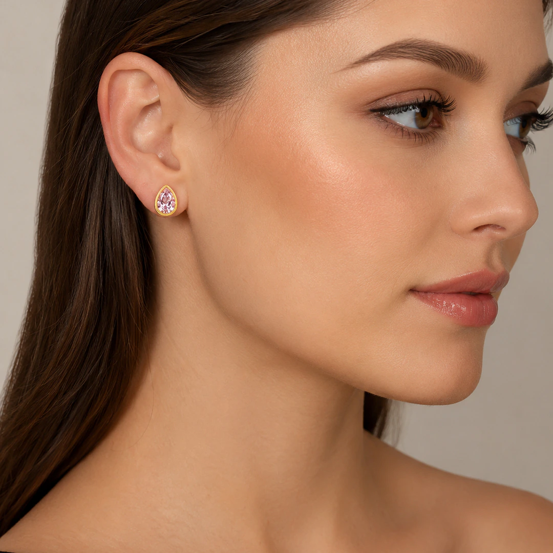 Puce d'oreille dorée à pierre rose en goutte portée à l'oreille, femme de profil