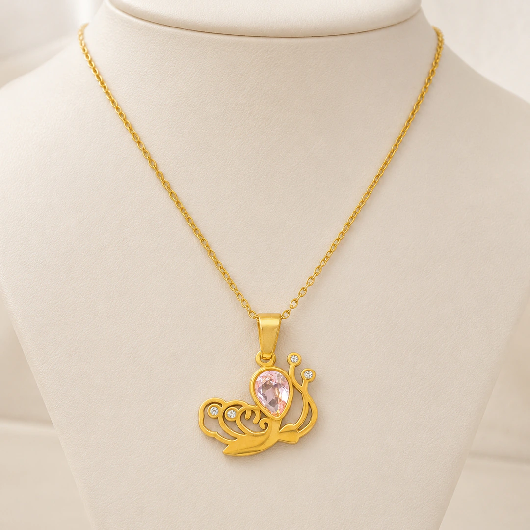 Pendentif escargot doré aux courbes ajourées et pierre rose facettée sur buste blanc