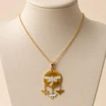 Médaillon doré à libellule en strass et petits papillons pendants présenté sur buste beige
