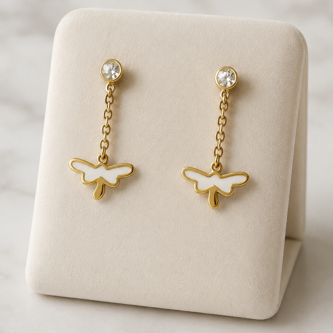 Boucles d'oreilles pendantes dorées à puce cristal, chaînette et papillon blanc sur présentoir