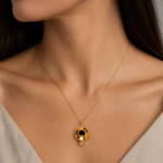 Collier chaîne fine doré à pendentif rond effet écaille porté au cou, vue rapprochée