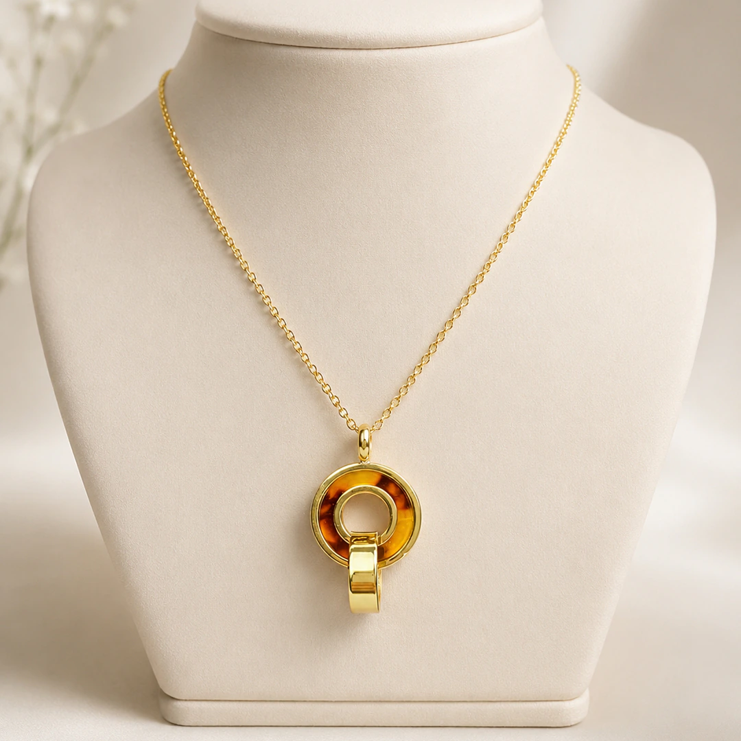 Collier pendentif cercle effet écaille brun ambré et anneau doré sur buste de présentation