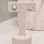 Puces d'oreilles rondes argentées pavées de strass sur présentoir en T beige