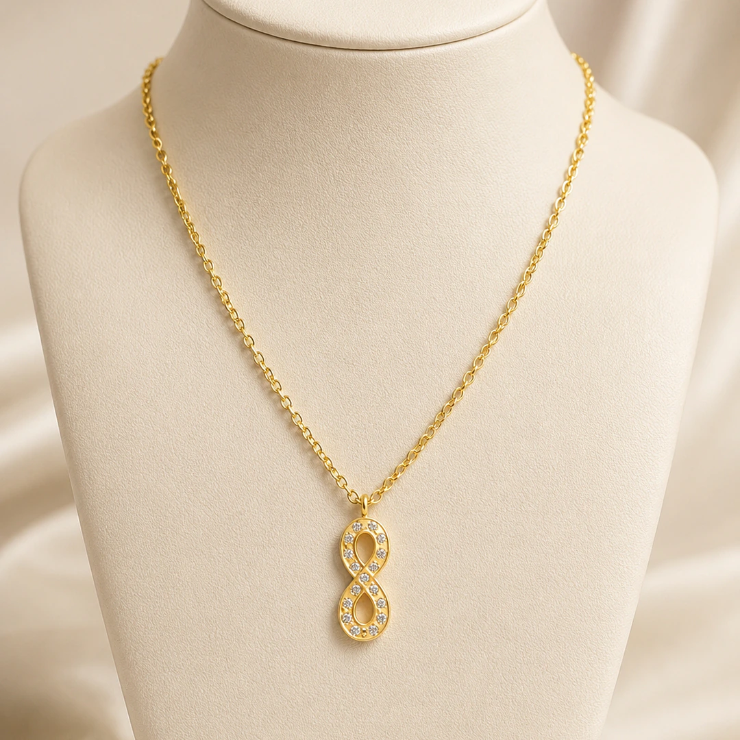 Collier chaîne dorée à pendentif infini vertical pavé de strass sur buste beige