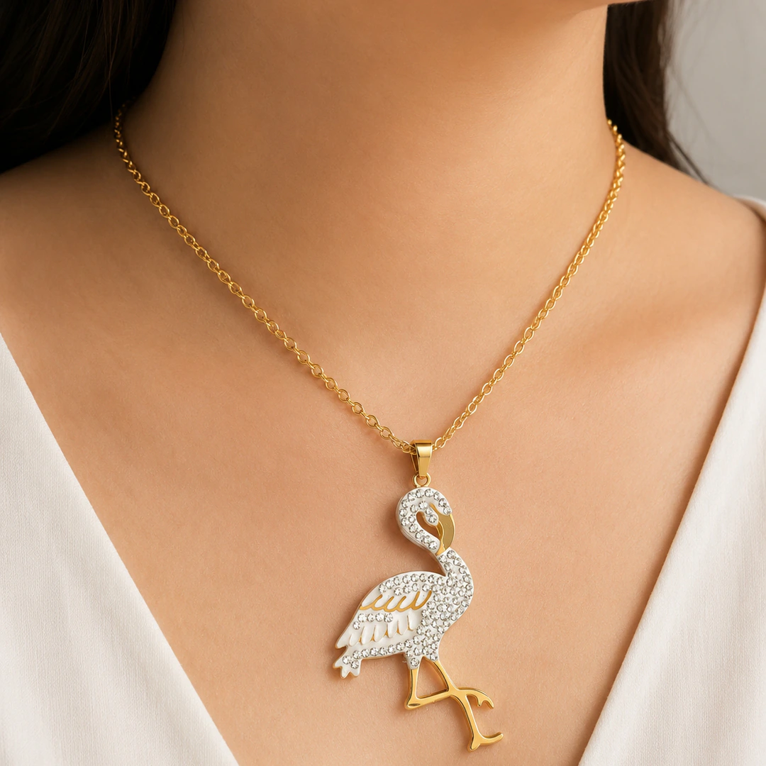 Collier pendentif flamant doré et blanc pavé de strass porté au cou, vue rapprochée