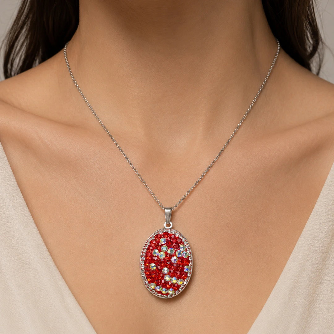Collier argenté à pendentif ovale en strass rouges et irisés porté au cou