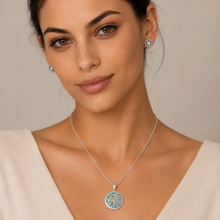 Parure argentée femme portée : collier médaillon rond irisé et puces d'oreilles rondes assorties