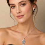 Parure argentée femme portée : collier pendentif allongé à strass bleus et créoles pavées de strass