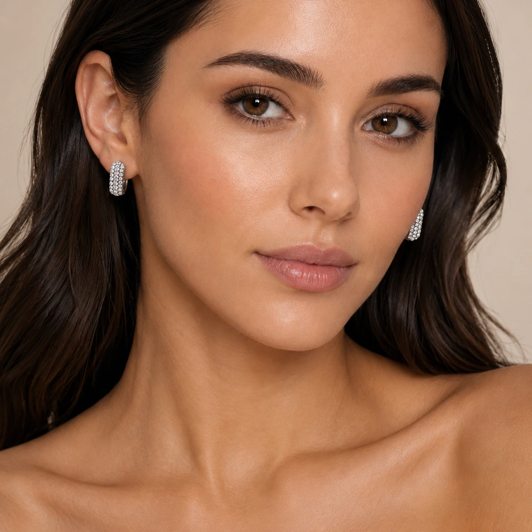 Créoles argentées femme pavées de strass portées aux oreilles, vue de face