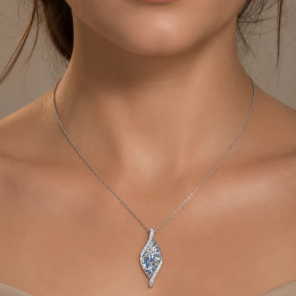 Collier argenté à chaîne fine et pendentif allongé serti de strass bleus porté au cou