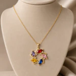 Pendentif rond doré à pierres navette rouge, rose, bleue, jaune et violette sur buste