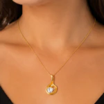 Collier chaîne fine doré à pendentif goutte ajourée et cristal cœur porté au cou