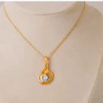 Pendentif goutte doré ajouré serti d'un cristal en forme de cœur sur buste beige
