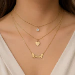 Collier trois rangs doré porté au cou : cristal, pendentif cœur et inscription Smile ailée