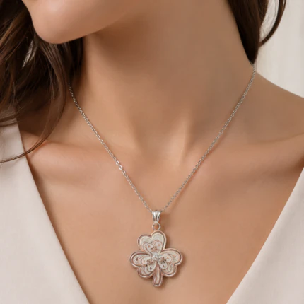Collier chaîne argentée à pendentif trèfle travaillé en filigrane porté au cou