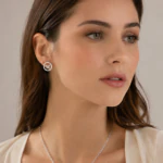 Femme portant une puce d'oreille ronde argentée à motif papillon ajouré