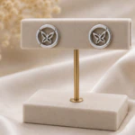 Boucles d'oreilles rondes argentées à papillon ajouré dans un anneau sur présentoir en T