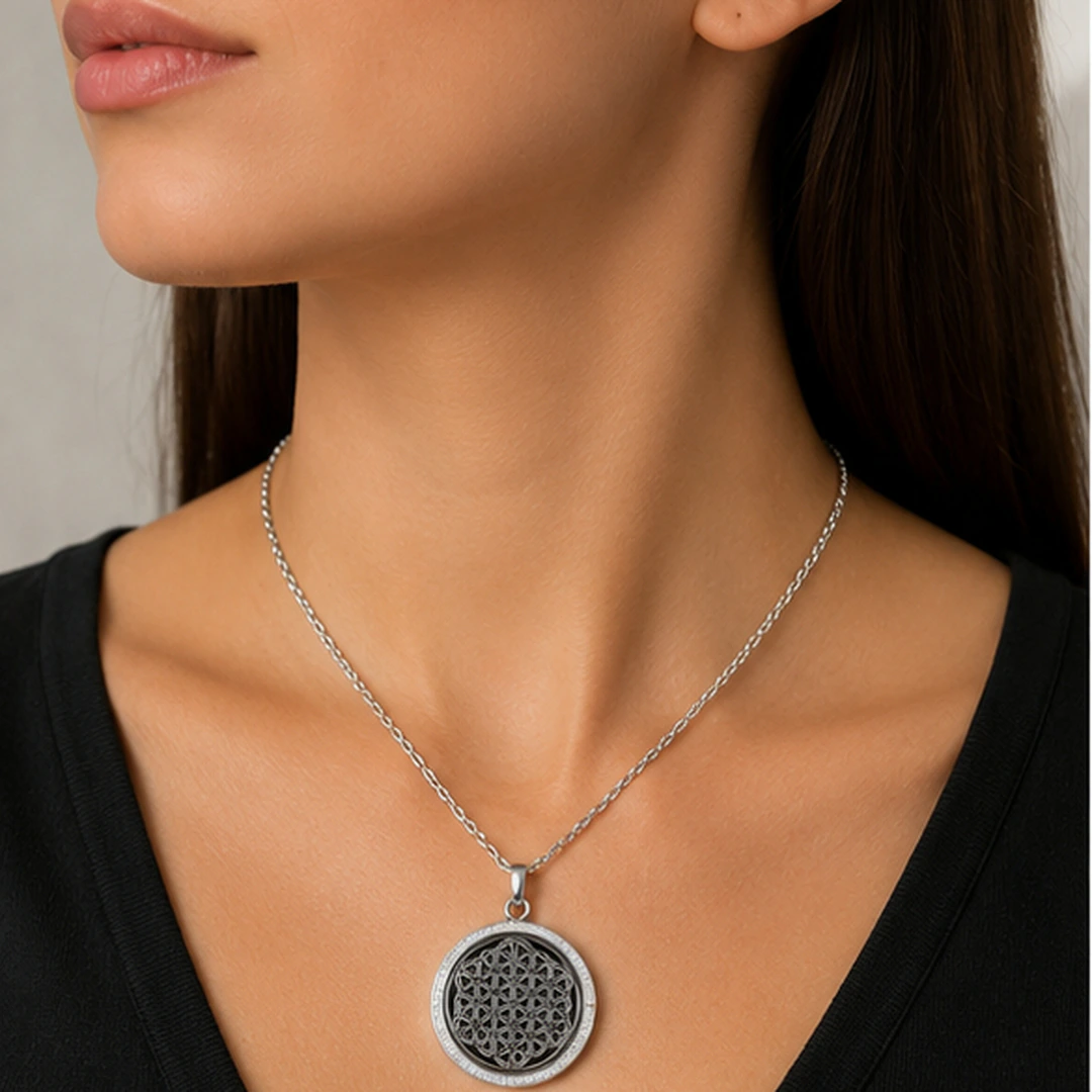 Collier argenté à médaillon rond noir à motif géométrique et bordure de strass porté au cou