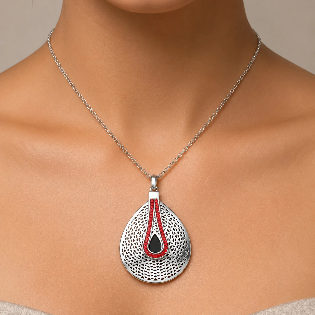 Collier argenté à grand pendentif goutte perforé orné d'une ligne de strass rouges porté au cou