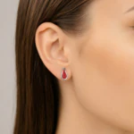 Boucle d'oreille goutte argentée pavée de strass rouges portée à l'oreille