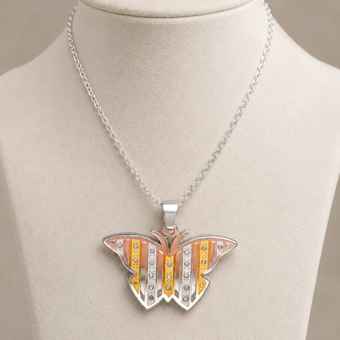 Pendentif papillon à bandes argentées, dorées et rose doré ponctuées de strass sur buste
