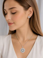 Parure argentée femme portée : collier médaillon rond floral ajouré et puces d'oreilles fleur