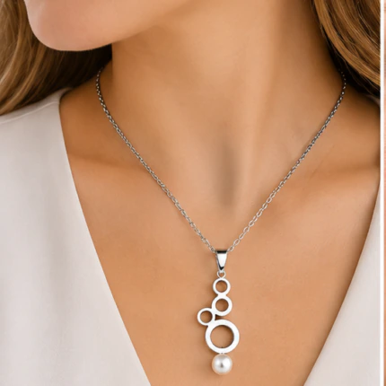 Collier chaîne argentée à pendentif cascade de cercles et perle blanche porté au cou