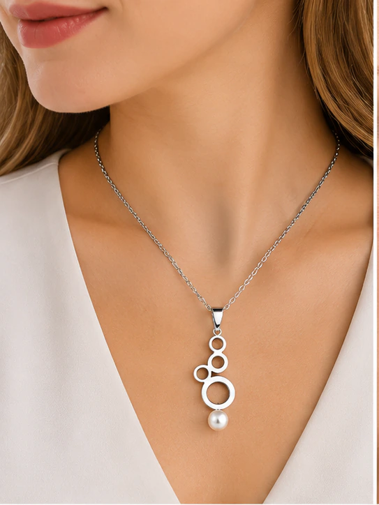 Collier chaîne argentée à pendentif cascade de cercles et perle blanche porté au cou