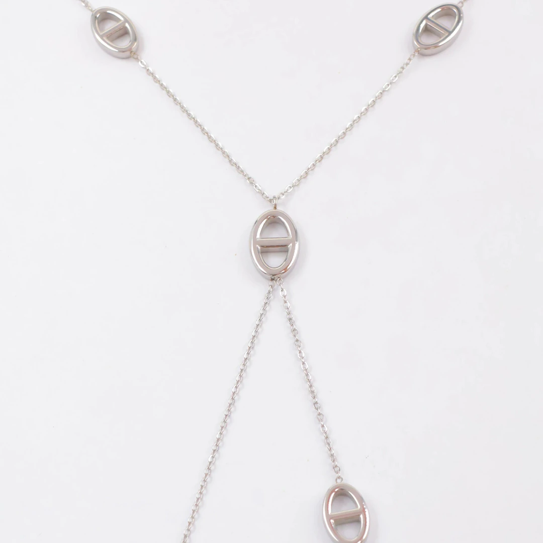 Collier sautoir argenté en vue de détail : chaîne fine et pendentifs ovales ajourés à barrette