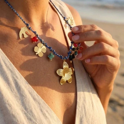 Collier bohème femme à cordon bleu tressé et breloques dorées et colorées, porté au cou à la plage