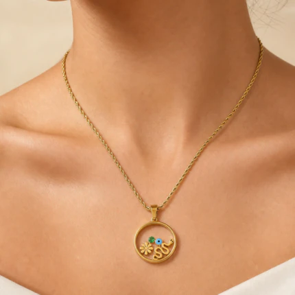 Collier doré femme à pendentif rond ajouré orné d'une fleur, d'un serpent et d'un mauvais œil, porté au cou