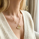 Collier doré femme à pendentif fleur et perles blanches