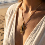 Collier doré femme à pendentif feuille et détail noir