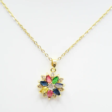 Gros plan du pendentif fleur aux pétales facettés rose, vert, bleu et jaune sur chaîne fine dorée